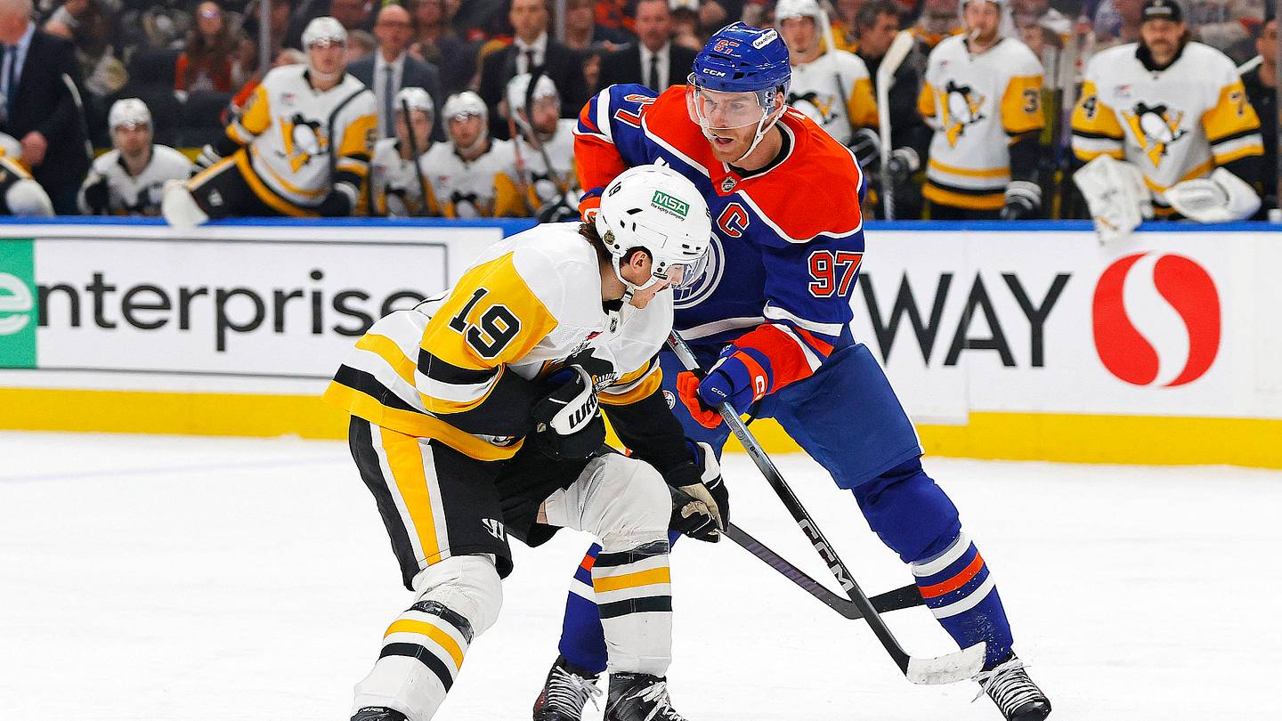 Jan 22, 2026; Edmonton, Alberta, CAN; Pittsburgh Penguins forward Connor Dewer (19) and Edmonton Oilers forward Connor McDavid (97) battle for a loose puck during the second period at Rogers Place. Mandatory Credit: Perry Nelson-Imagn Images