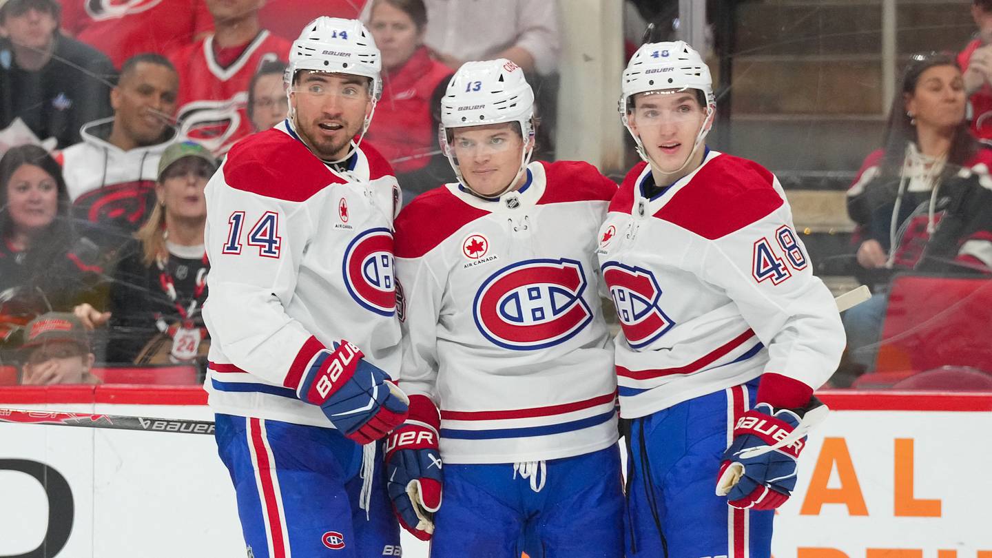 Mar 29, 2026; Raleigh, North Carolina, USA;  Montreal Canadiens center Nick Suzuki (14) is congratulated by defenseman Lane Hutson (48) and right wing Cole Caufield (13) after his goal against the Carolina Hurricanes during the second period at Lenovo Center. Mandatory Credit: James Guillory-Imagn Images