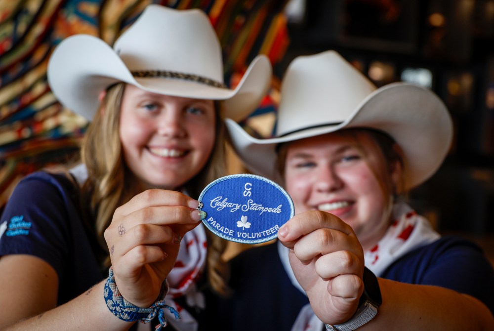 Ayla Loewen-McKnight, left, and Emma Greig hold up Calgary Stampede parade volunteer patch they will earn in Calgary, Monday, June 29, 2026. THE CANADIAN PRESS/Jeff McIntosh