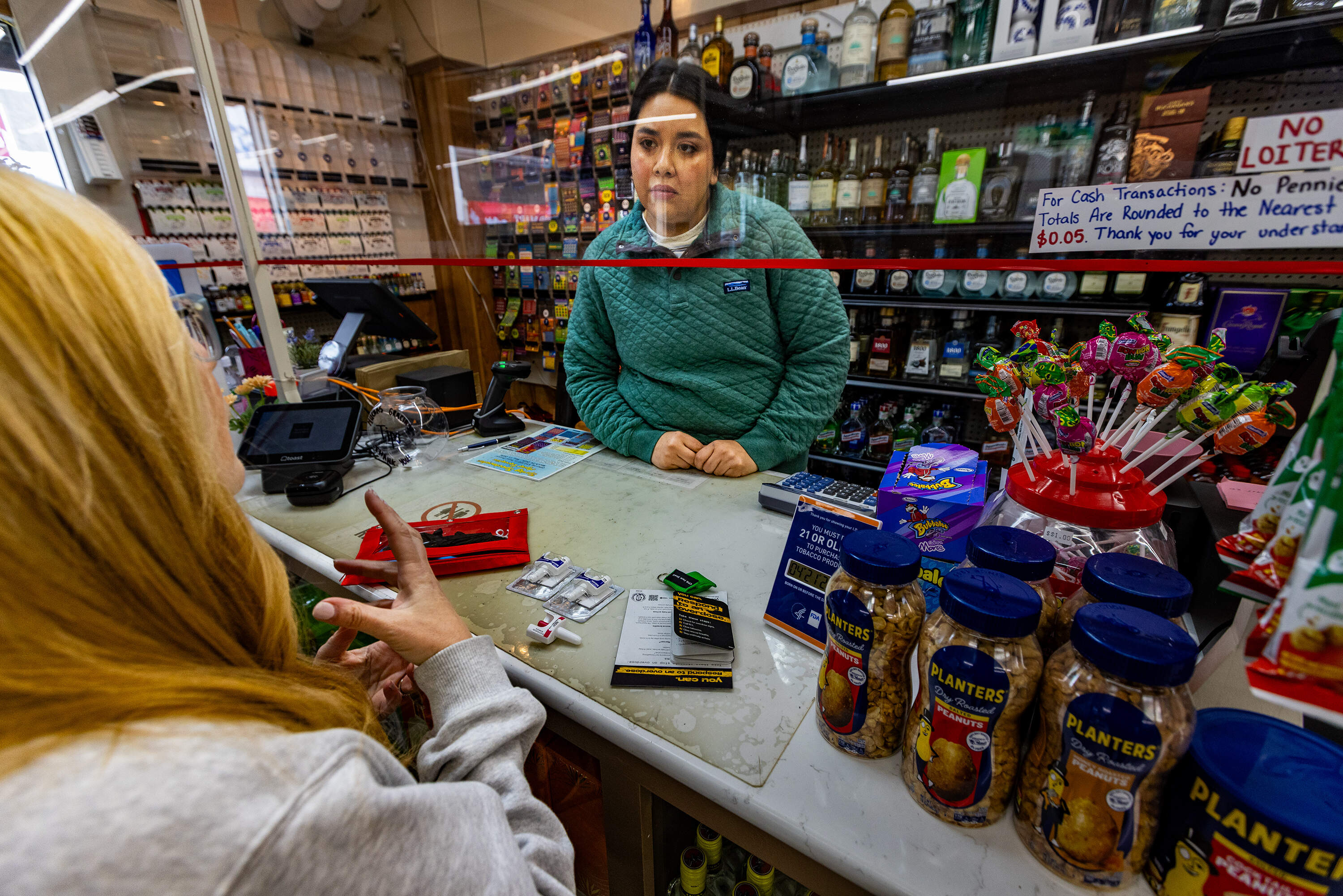 Claudia Cabrera of Wonderland Liquor Store in Revere listens to nurse Denise Hartley during the naloxone training. (Jesse Costa/WBUR)