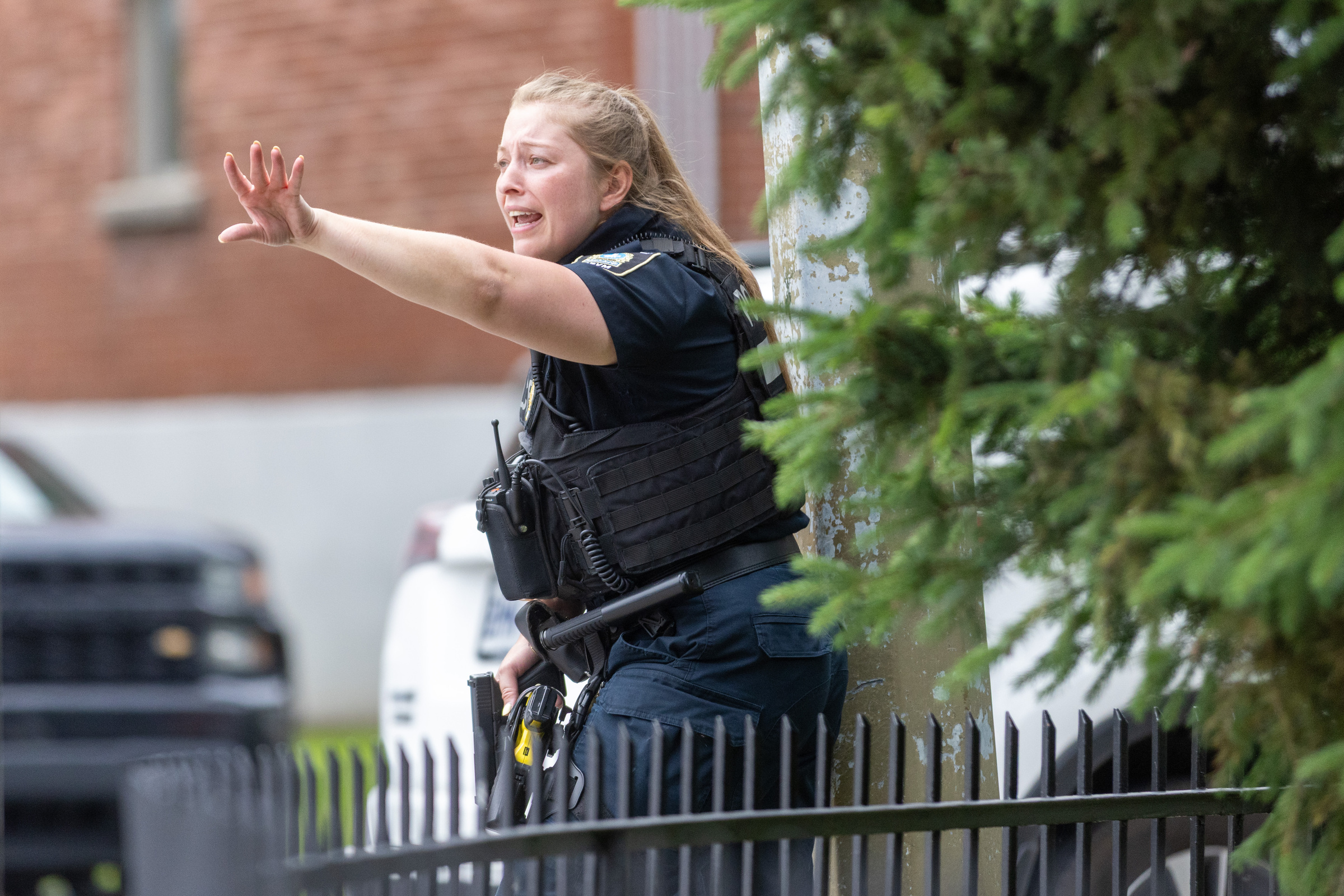 A Montreal police officer extends her arm as she gives a command to unseen people