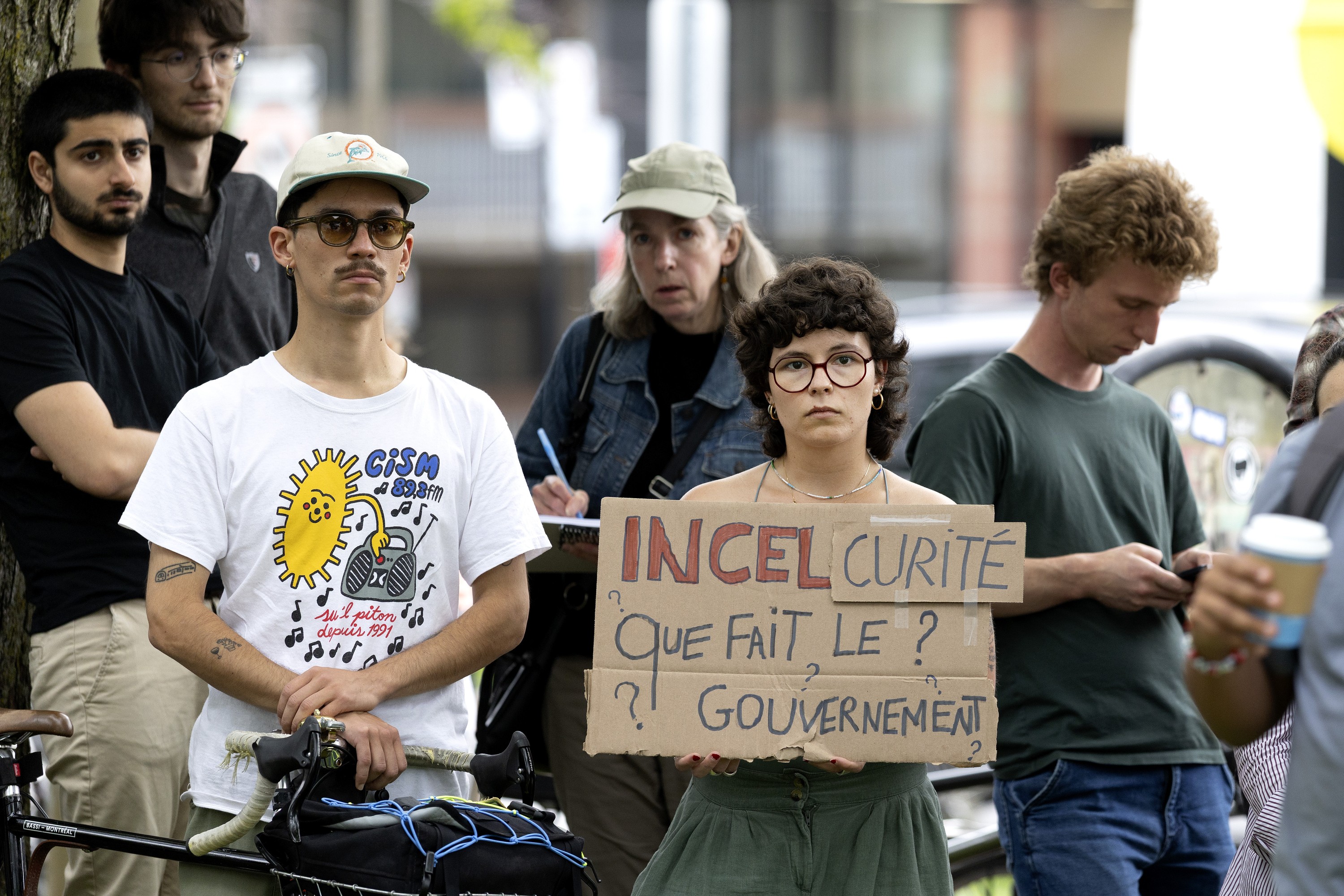 A small group of protesters includes one holding a sign reading in French: What is the government doing about incel-curity