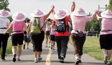 Women holding hands and wearing pink hats participate in the Weekend to End Breast Cancer in 2009.