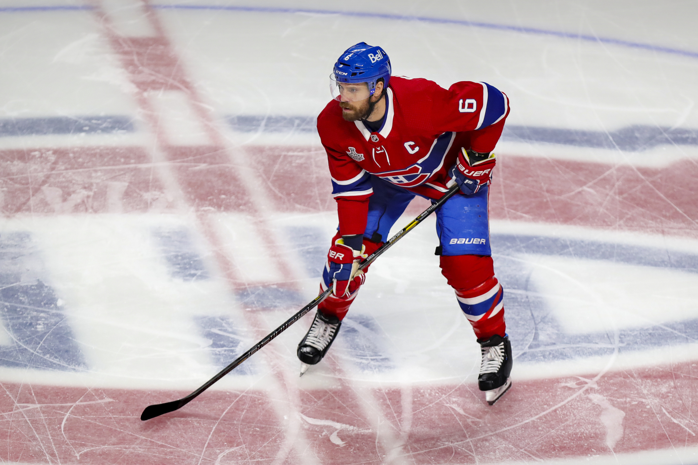 Shea Weber lines up for a face-off with the Montreal Canadiens logo visible on the ice beneath him.
