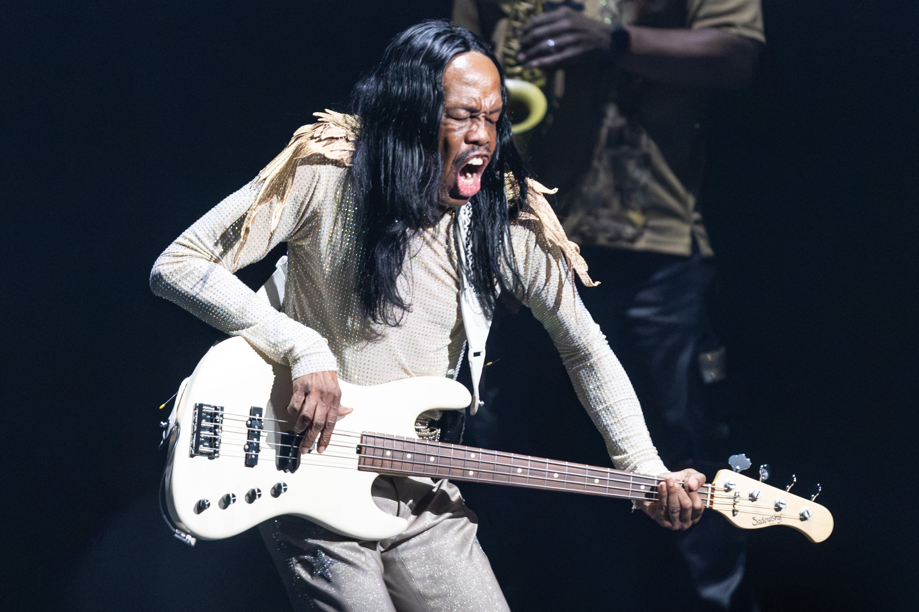 A man really slapping the bass guitar.