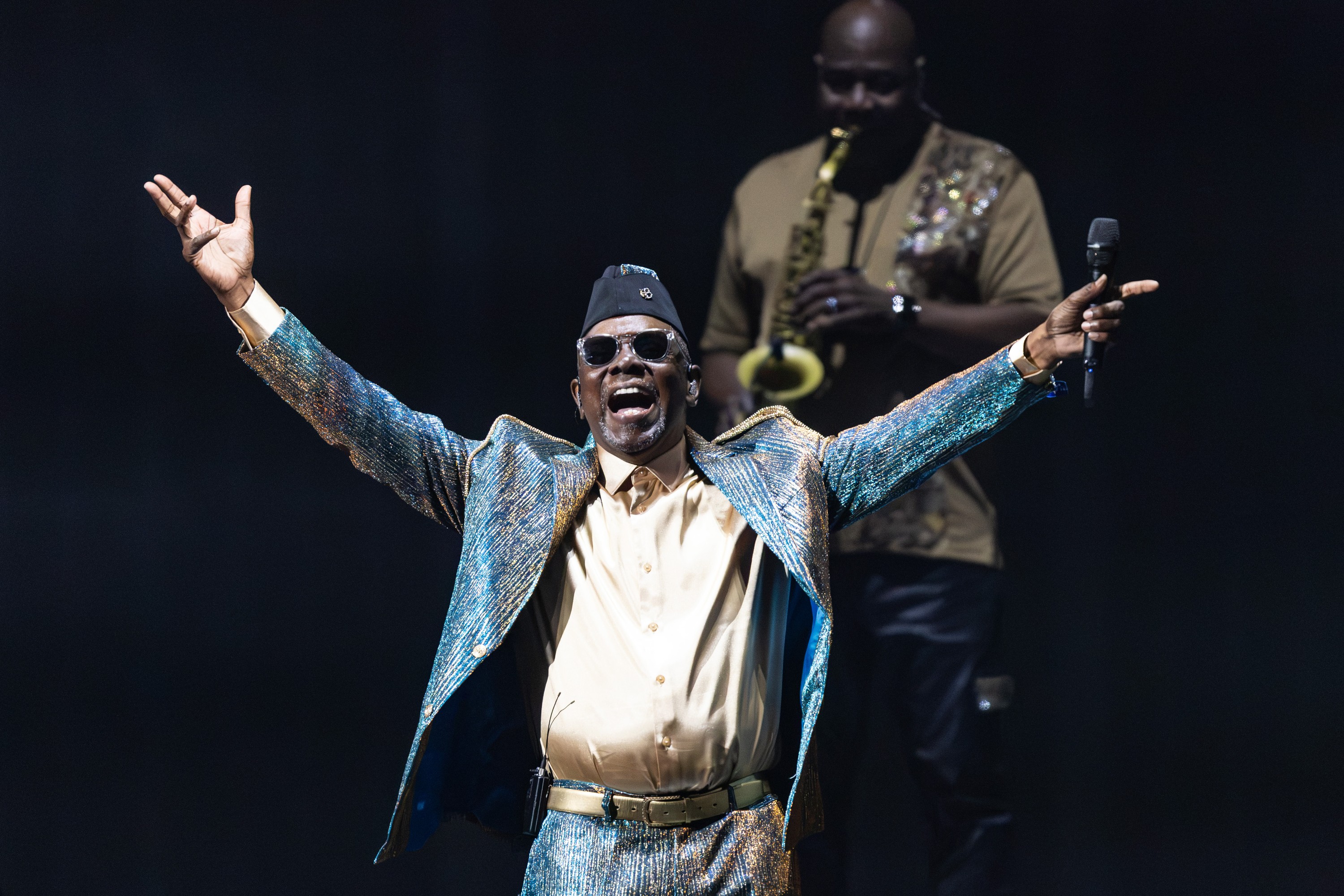 Philip Bailey of Earth, Wind & Fire gestures to the crowd during a concert