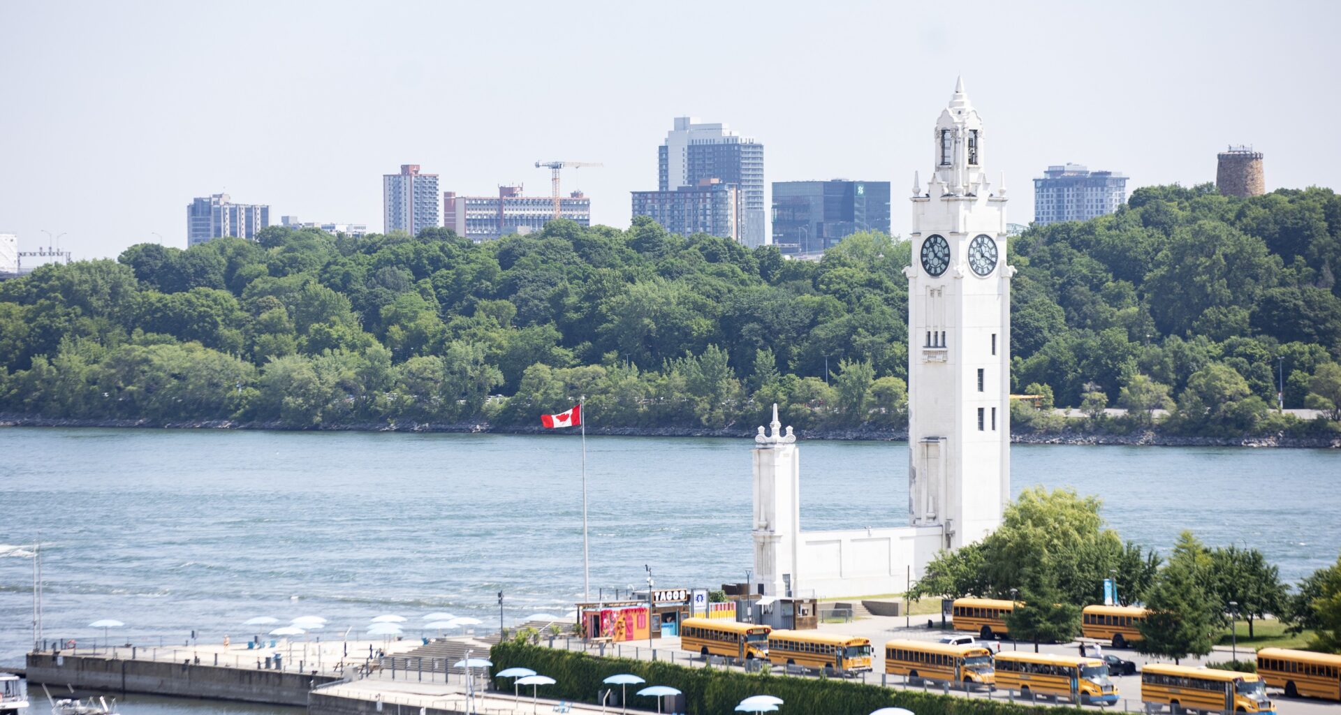 A clock tower is seen from altitude, looking out over docks and a river.