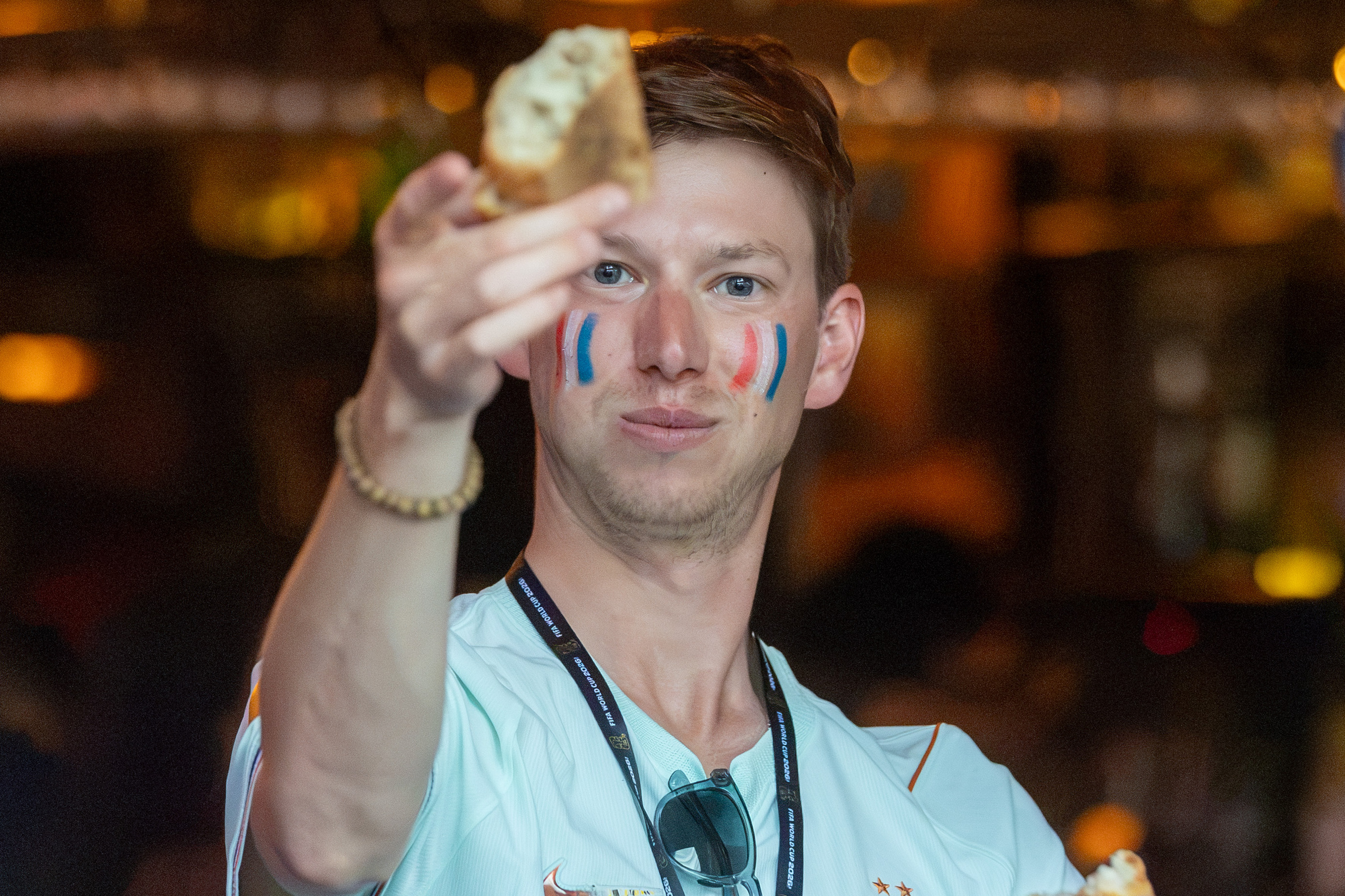 A man holds a piece of baguette in the air.