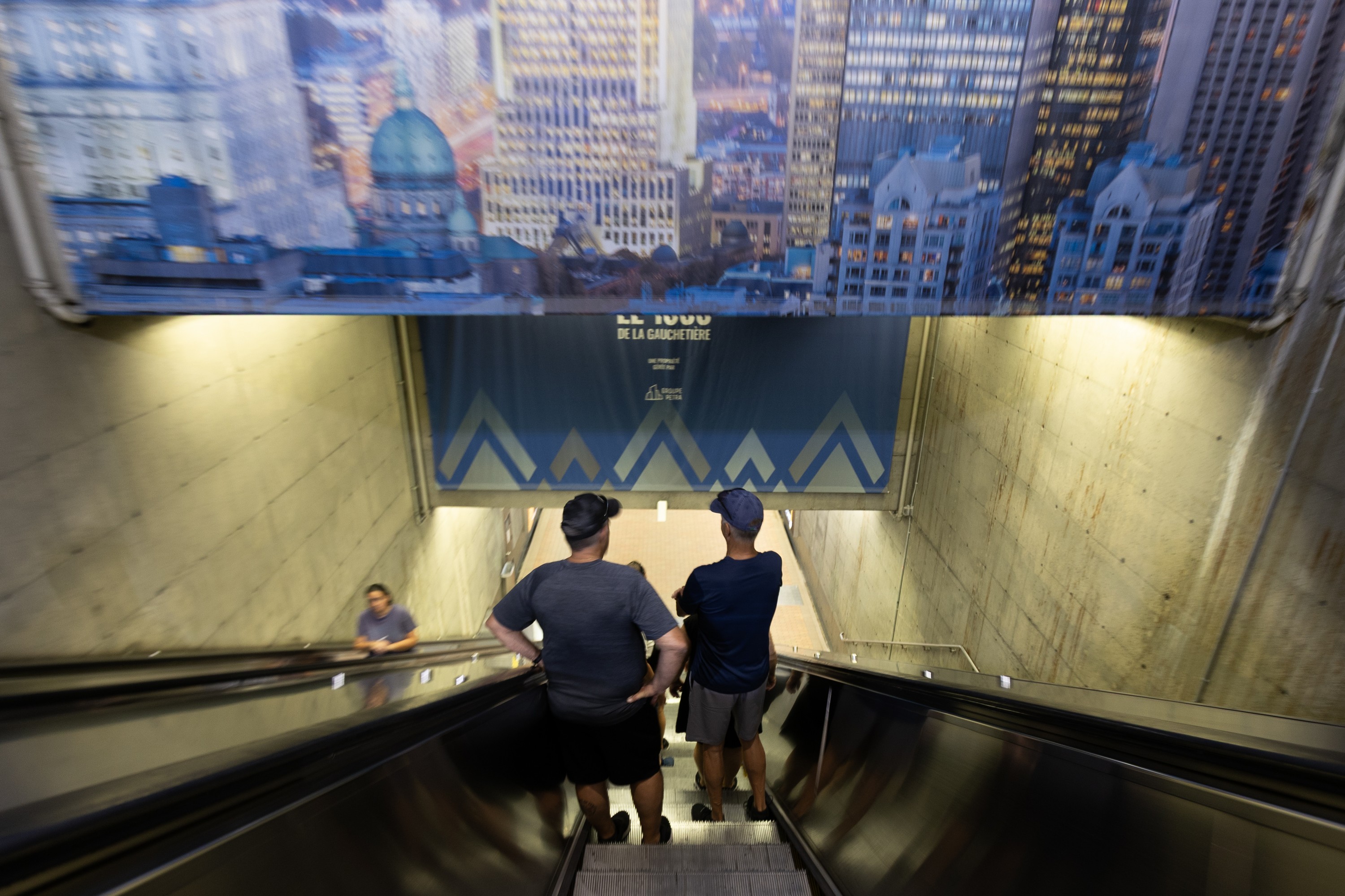 Narrow escalator in Central Station shows two people standing in single file.