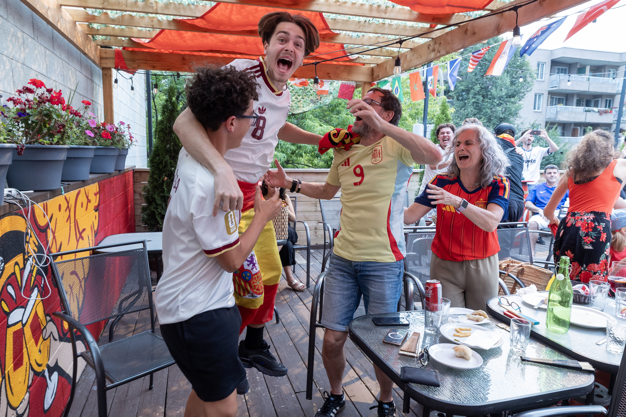 A man jumps in the air in celebration on an outdoor patio.