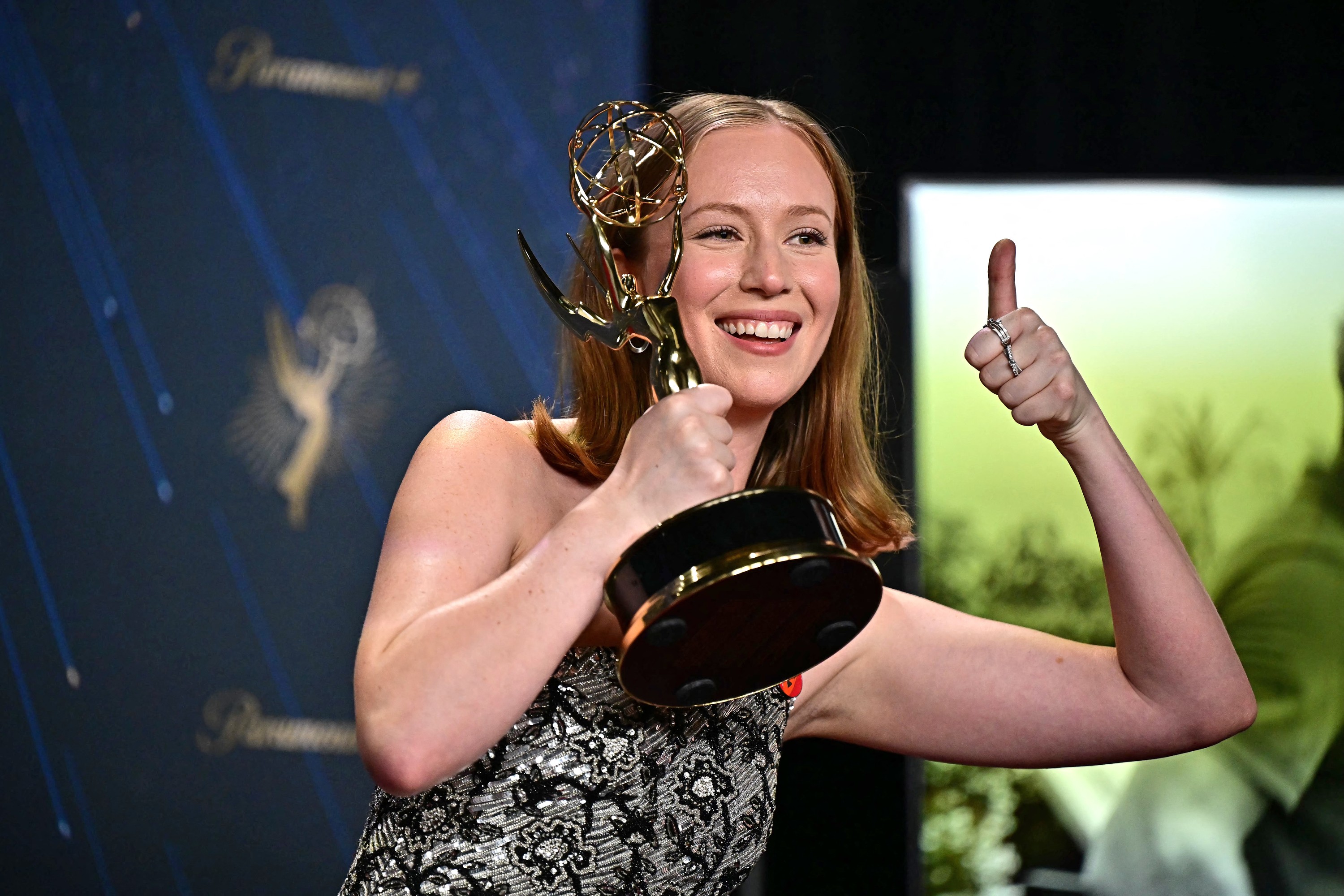 Actor Hannah Einbinder gives a thumbs-up while holding her Emmy Award for the show Hacks