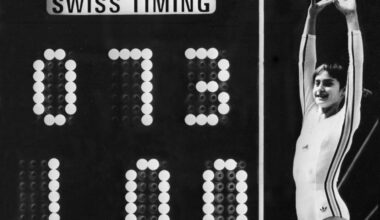 Romanian gymnast Nadia Comaneci celebrates on July 19, 1976 as the Montreal Forum scoreboard shows the perfect score of 10 – actually shown as 1.00, as the scoreboard wasn't built to show 10.00 – following her 1976 Montreal Olympic Games routine on the uneven bars.