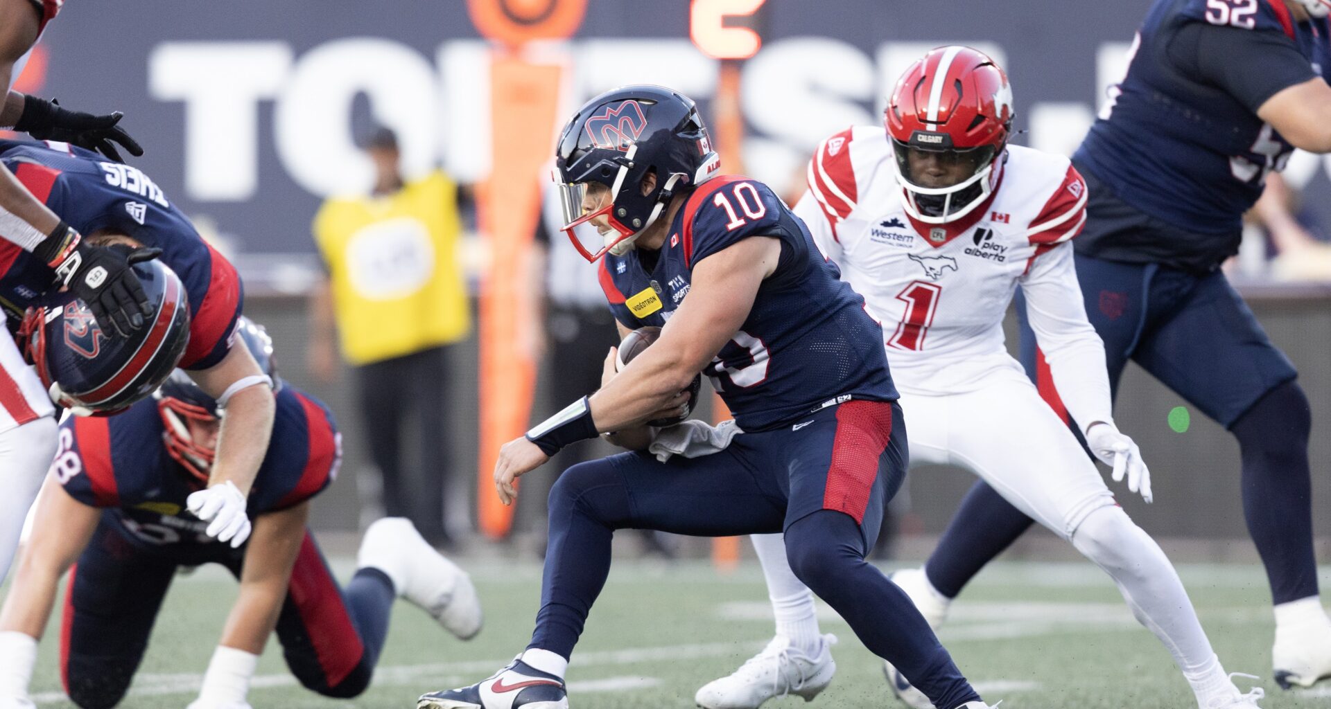 Alouettes quarterback Davis Alexander holds on to the football as he tries to escape pressure.