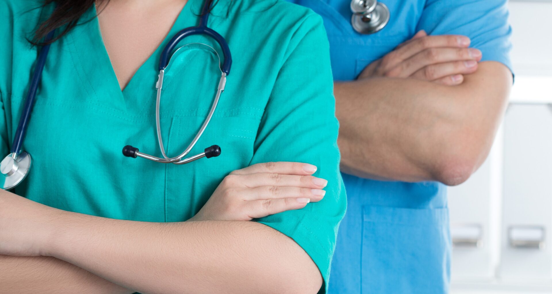 stock photo shows two physicians, one female and one male, with arms crossed and stethoscopes