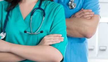 stock photo shows two physicians, one female and one male, with arms crossed and stethoscopes