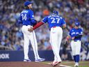 Kevin Gausman of the Toronto Blue Jays reacts just before being pulled from the game as Vladimir Guerrero Jr. approaches during a break in play against the Tampa Bay Rays.