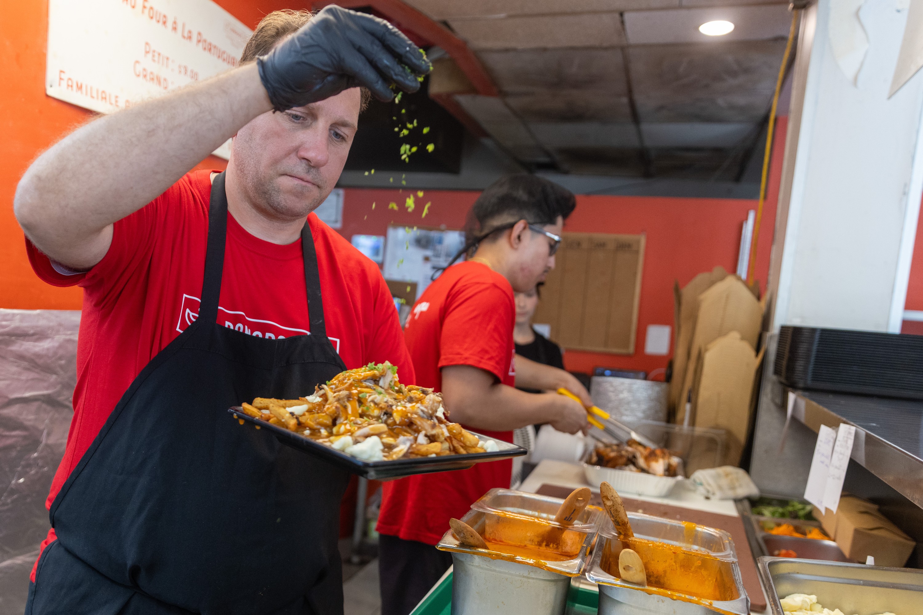 A chef sprinkles spices on food. 