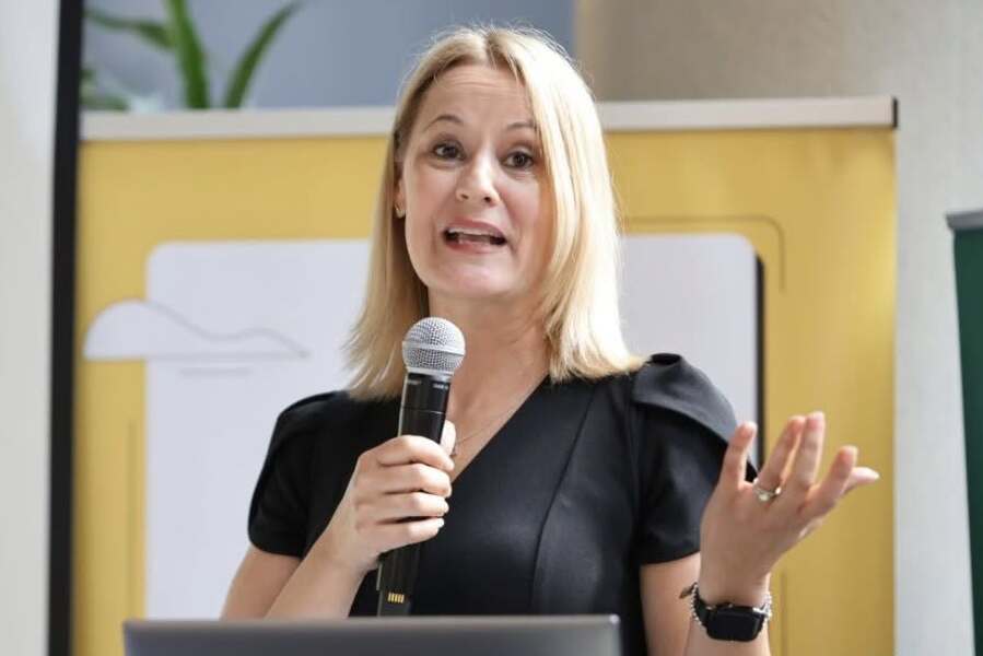 Elsie Lefebvre gestures while speaking into a microphone.
