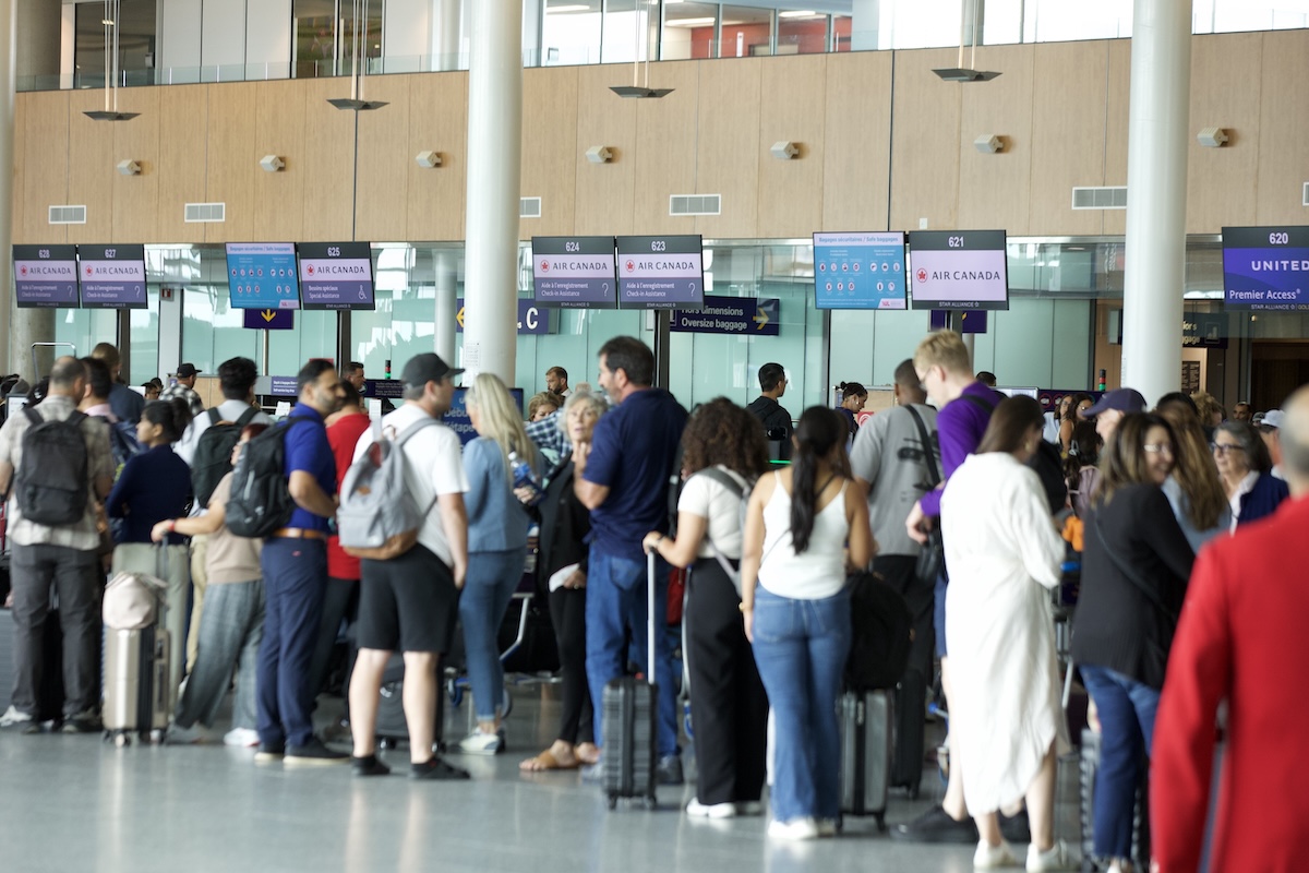 Crowds of people wait in lineups near the Air Canada counters at Trudeau airport.