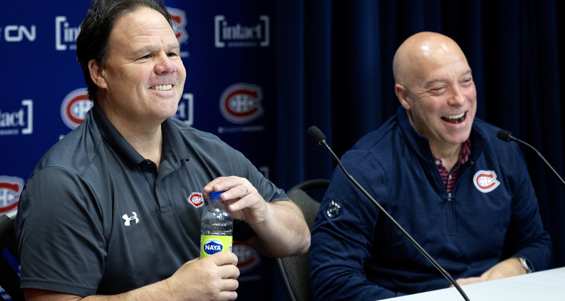 Jeff Gorton, president of hockey operations, left, and GM Kent Hughes laugh while talking to the media.