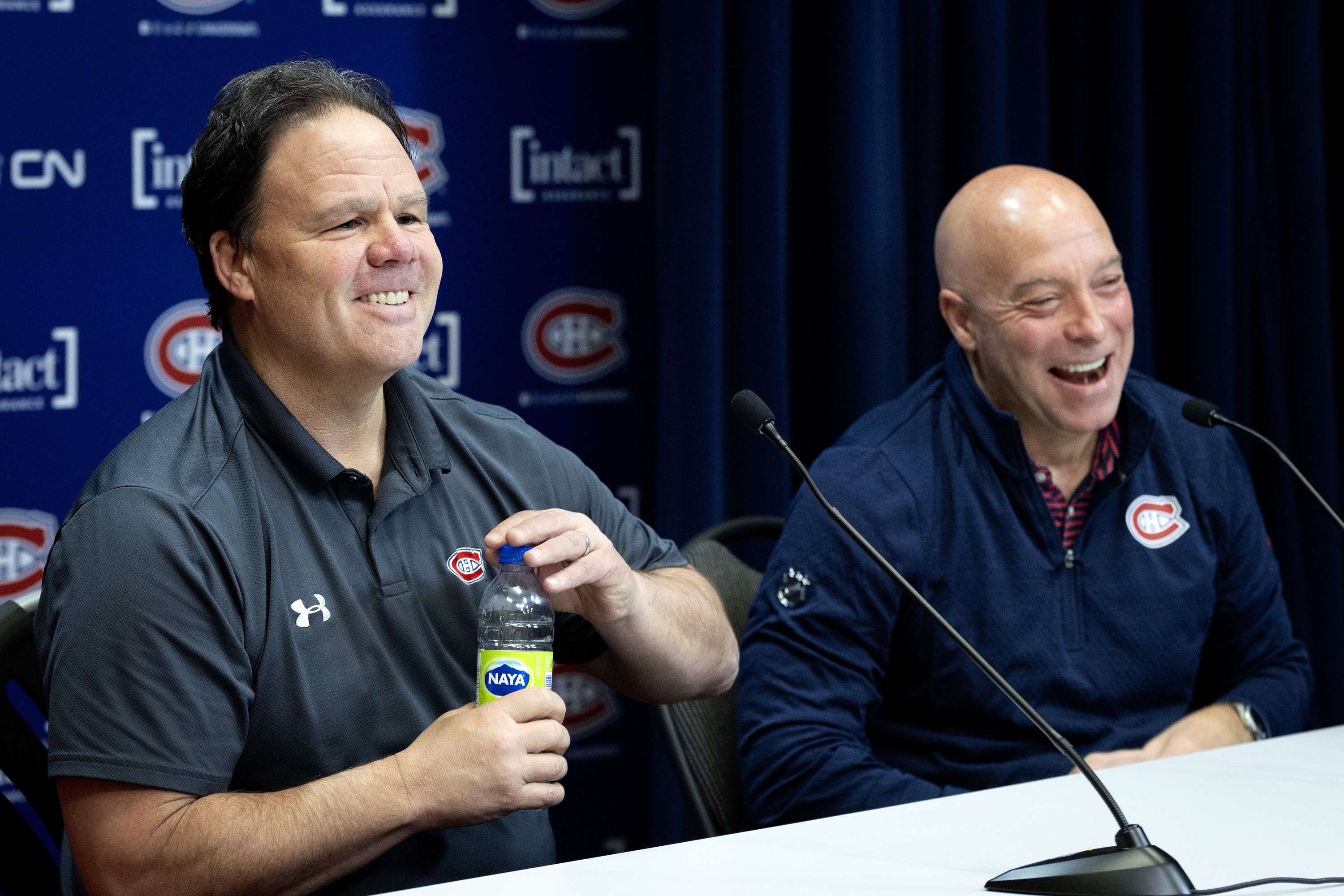 Jeff Gorton, president of hockey operations, left, and GM Kent Hughes laugh while talking to the media.