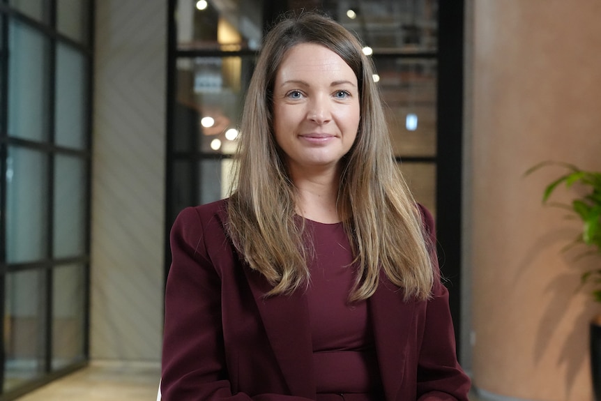 Nicola Powell smiling, wearing a burgundy top
