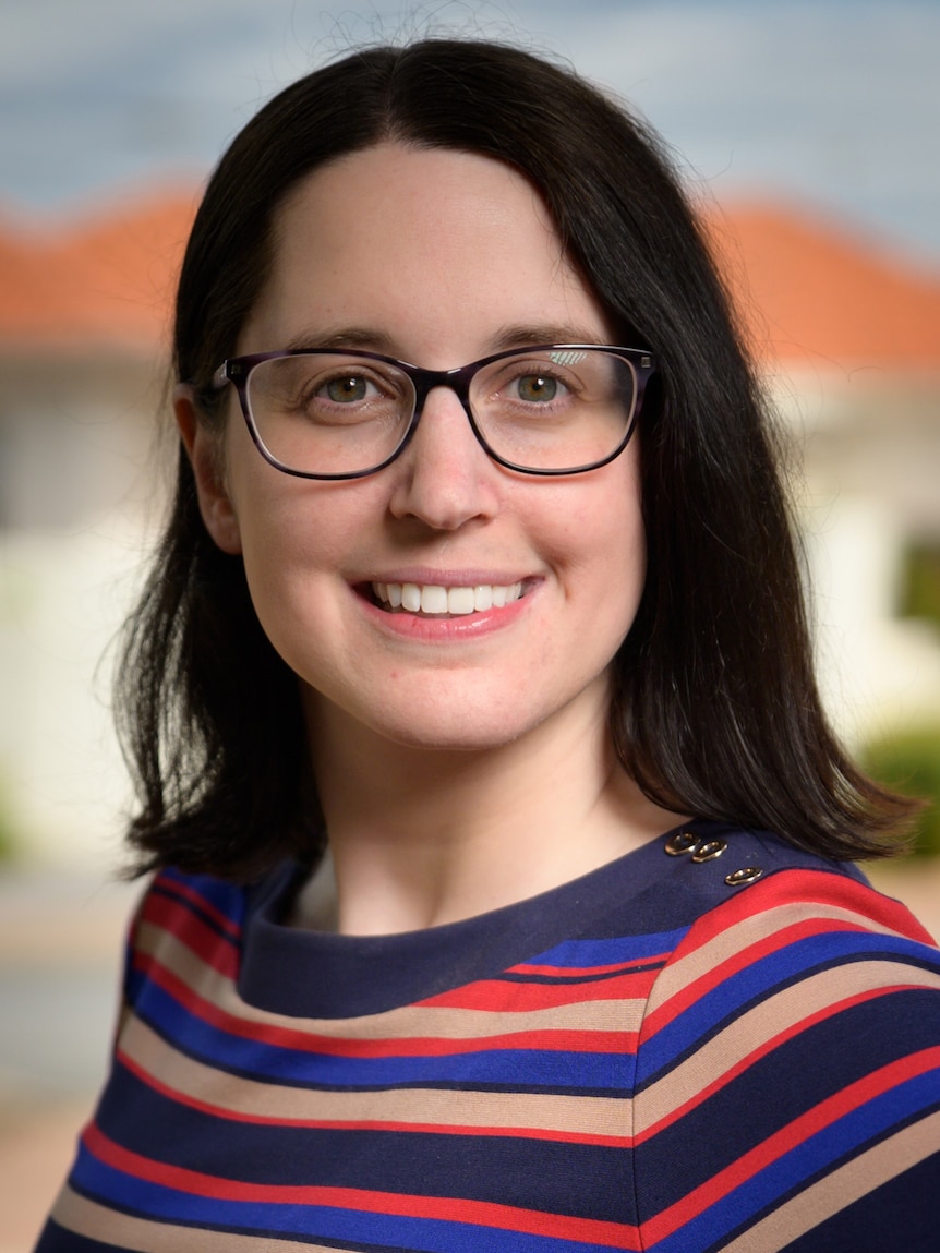 A close-up shot of a woman's face wearing glasses