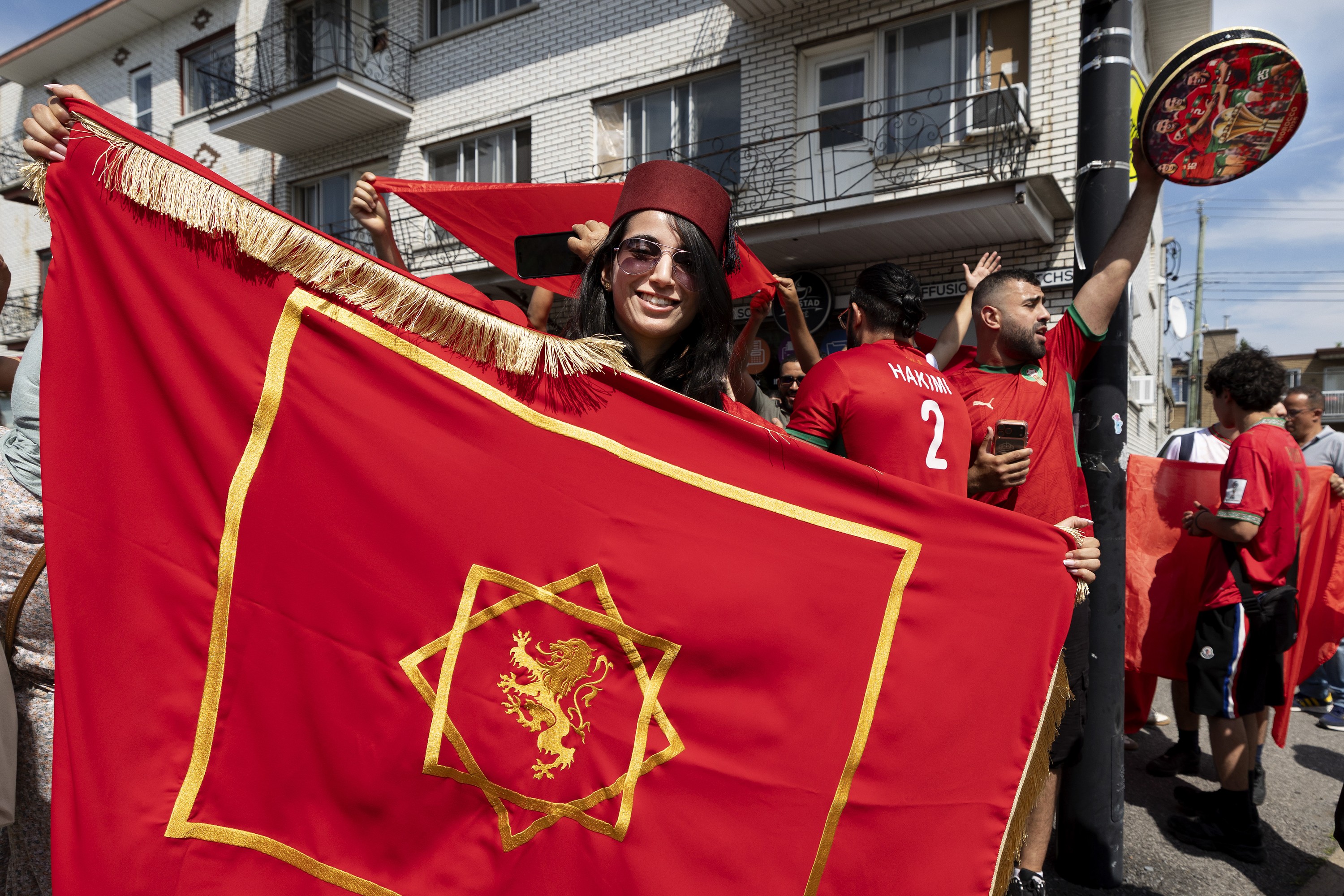 Soccer fan holds a flag during a watch party on the street. 