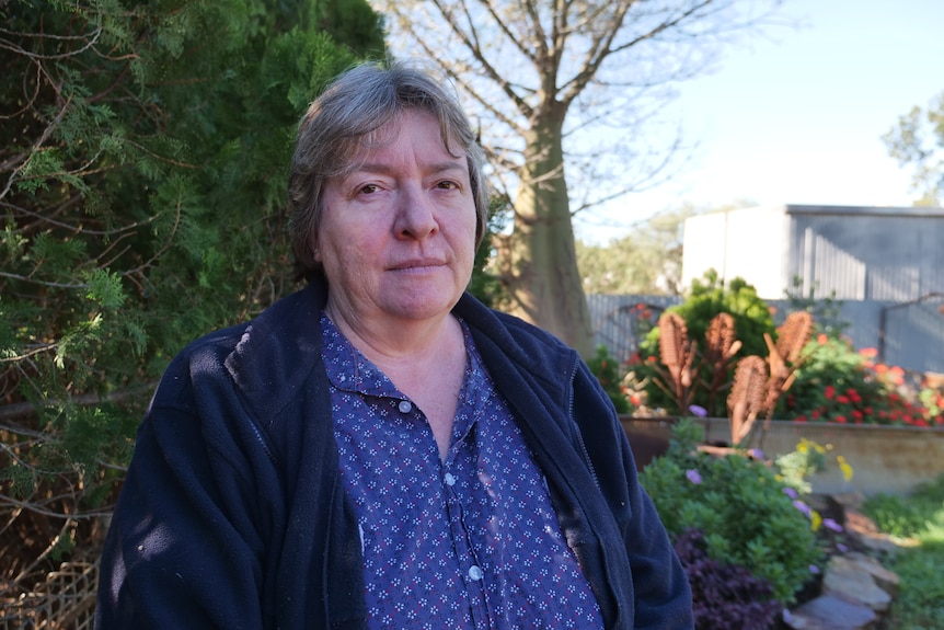Leanne looks at the camera with a solemn expression on her face.