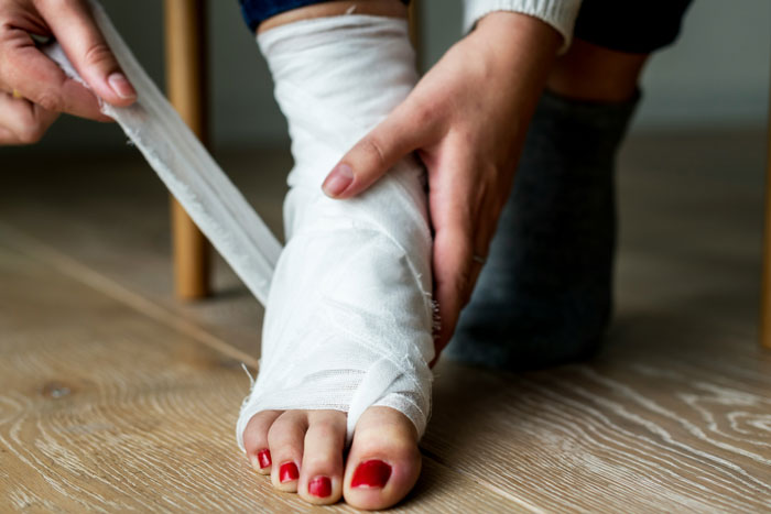 A person wrapping an injured foot, symbolizing patients who tried to outsmart their doctors and failed.