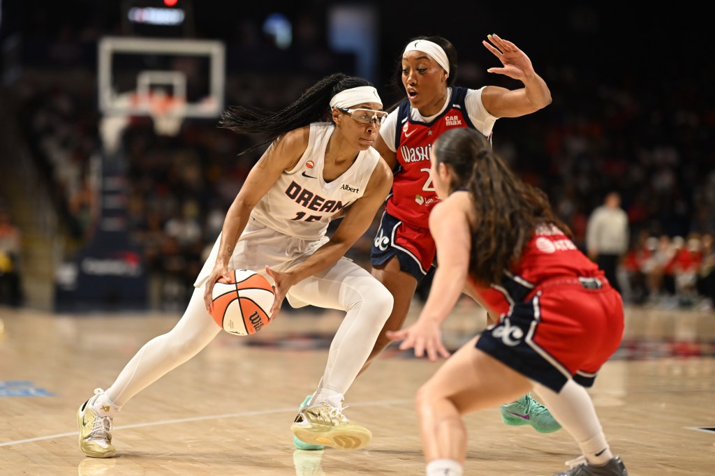 Atlanta Dream guard Allisha Gray dribbling the ball against Washington Mystics defenders Cotie McMahon and Georgia Amoore.