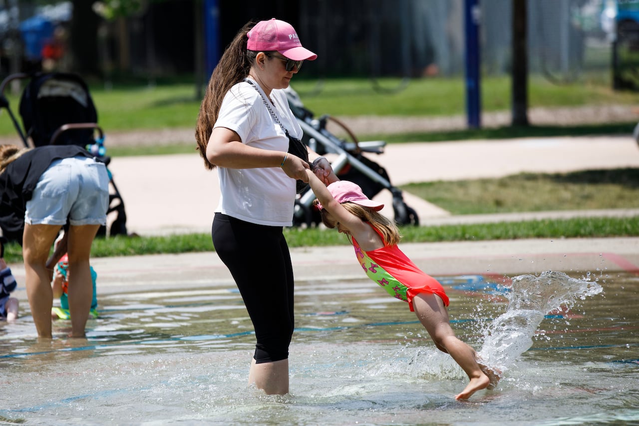 A child plays in a splashpad during a warm day at Sunnyside Park in Toronto on July 11, 2023.