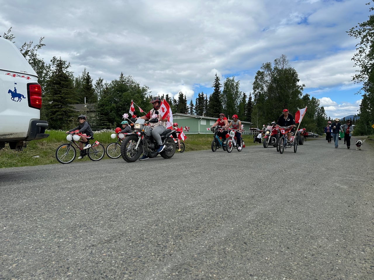 Cyclists ride bikes adorned with flags during a parade.