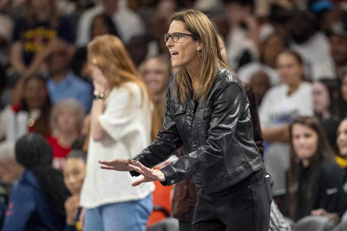 Stephanie White holds her hands out on the sidelines during a game
