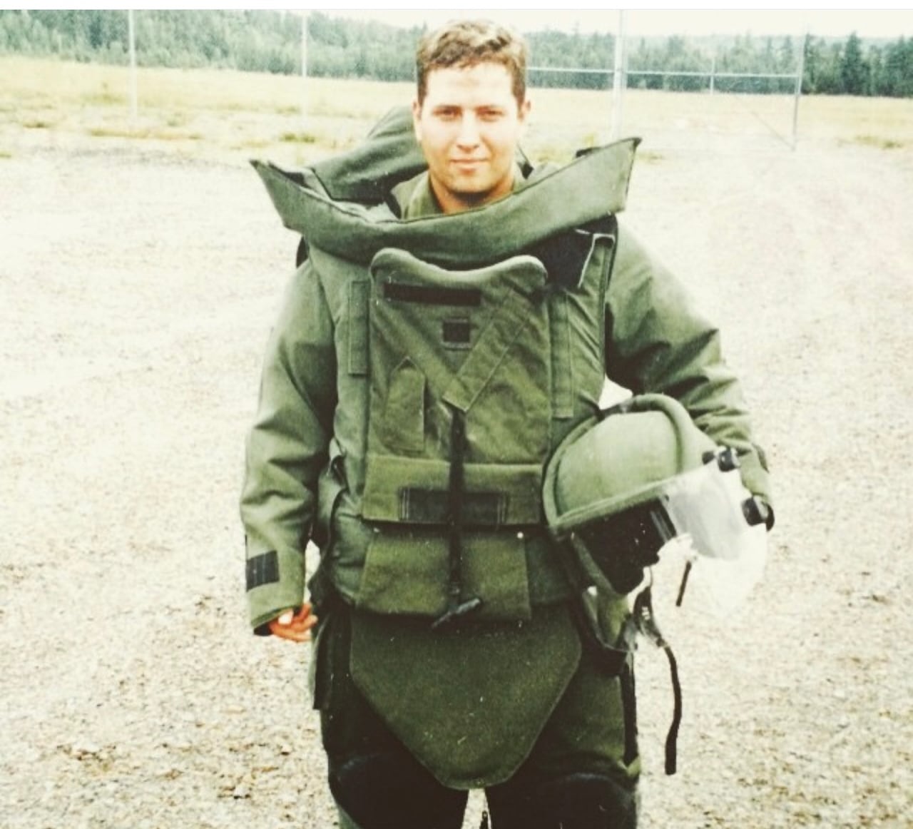 An older picture of an army member wearing green combat gear.