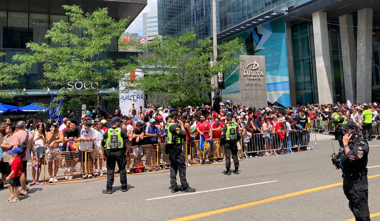 Fans line up as police maintain a barrier.