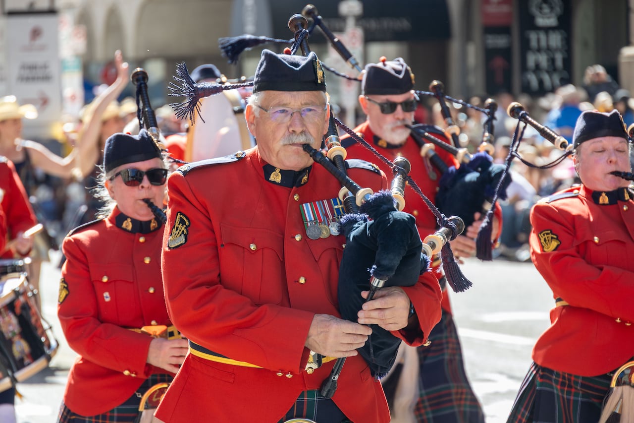 RCMP members play bagpipes.