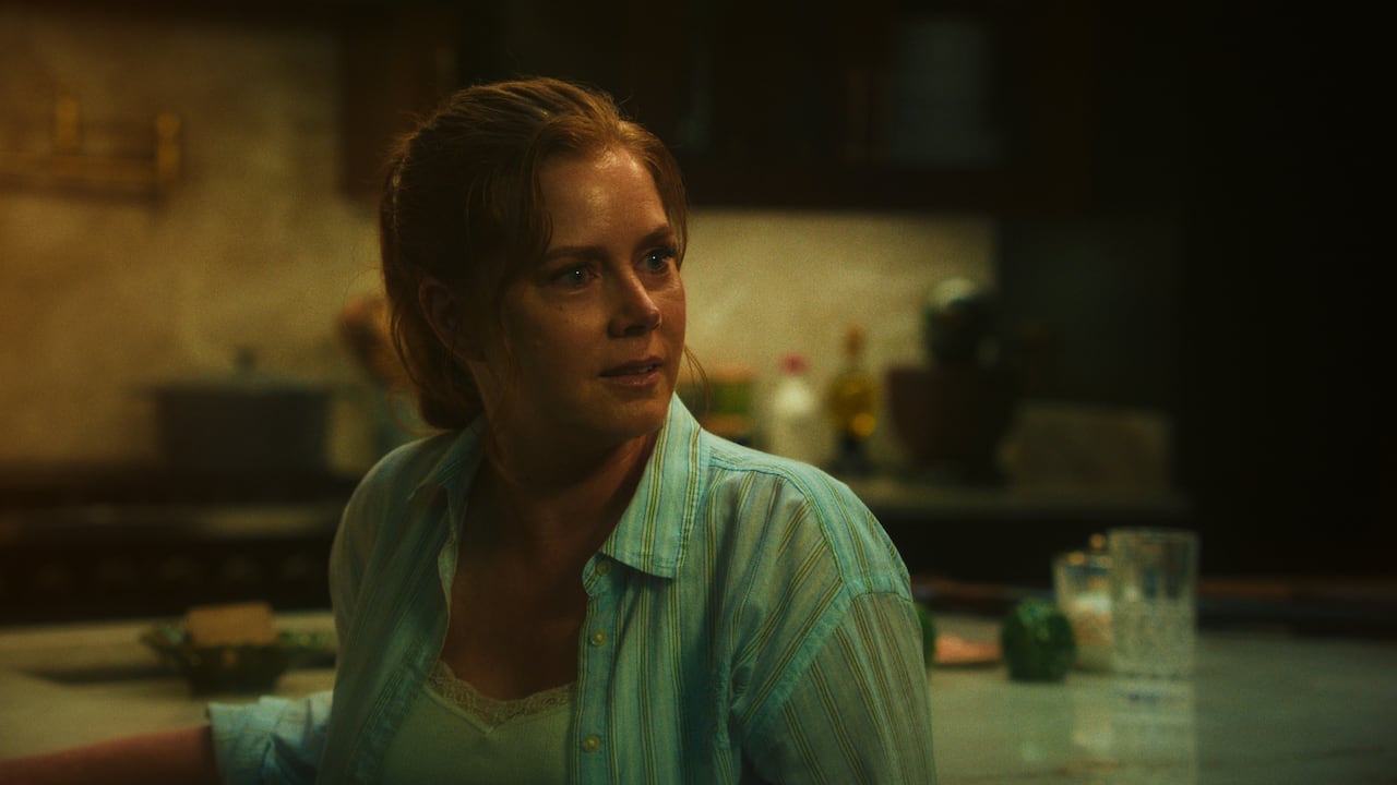 A woman sits at a kitchen island.