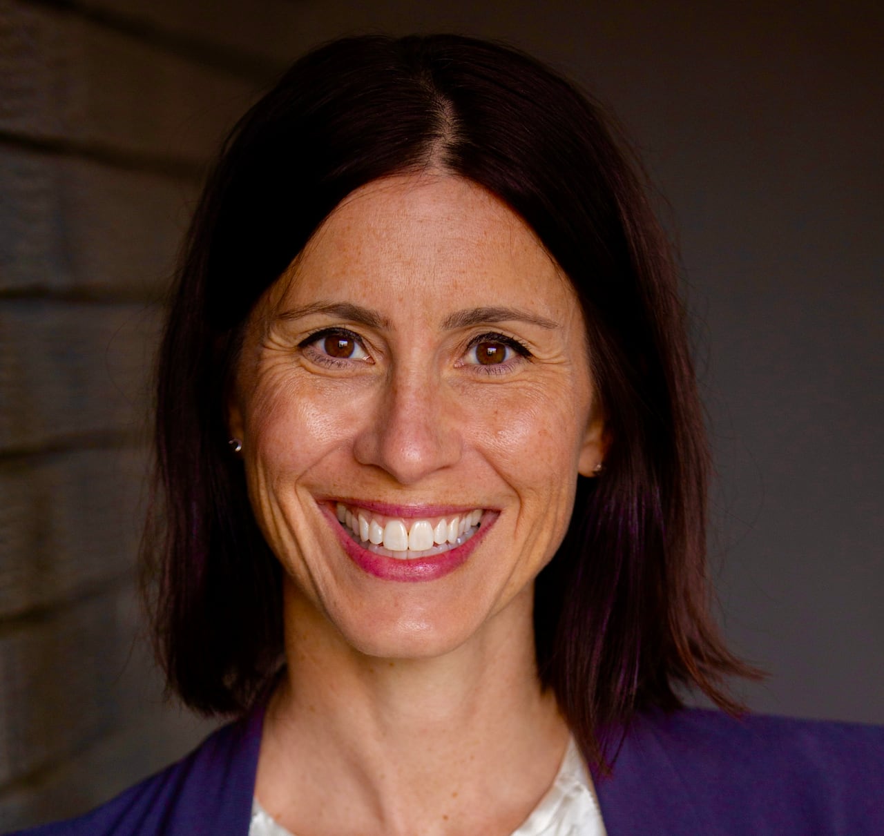 A woman smiles at the camera.