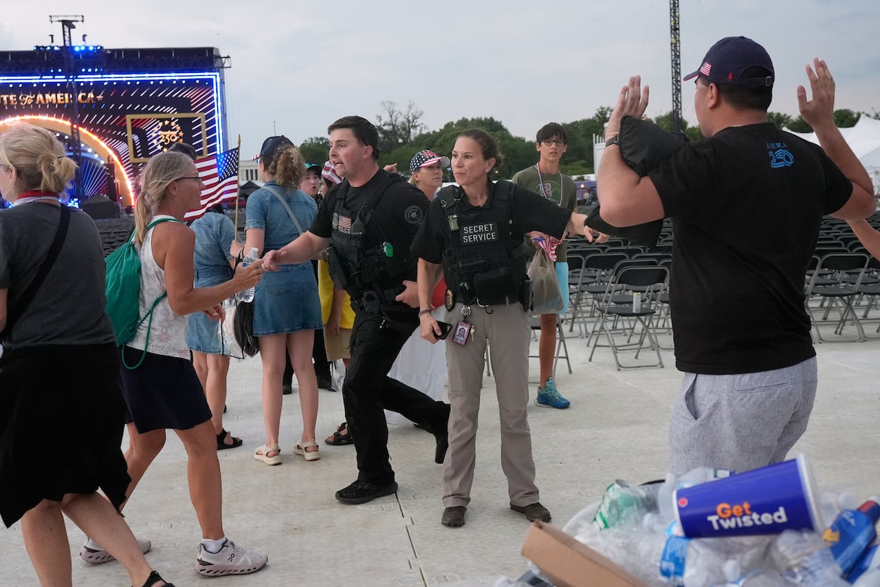 Security guards gesture at attendees.