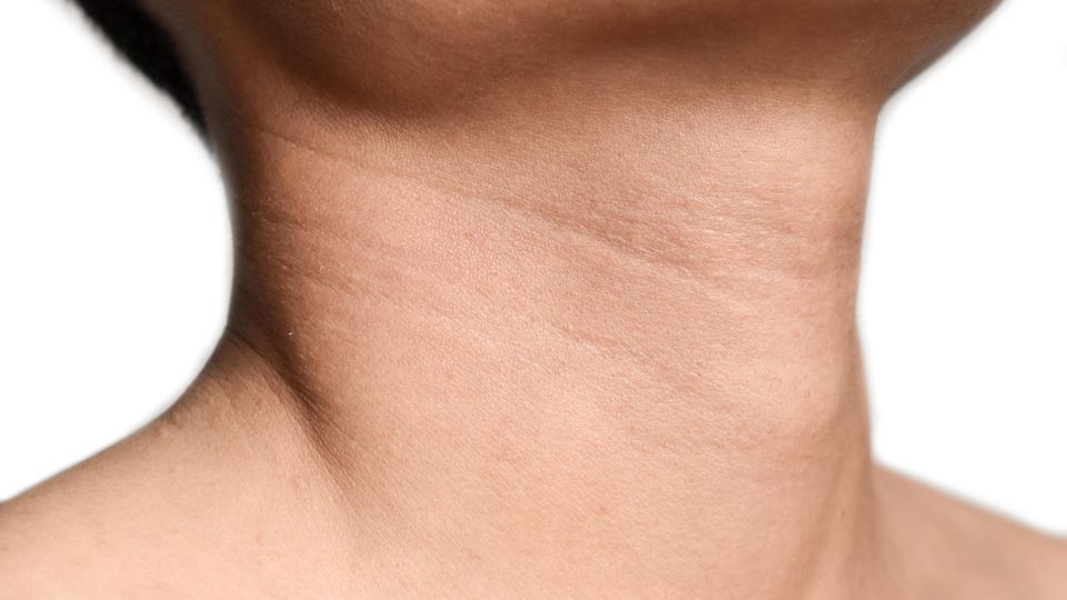 Aging skin folds or skin creases or wrinkles at neck of Asian old man. Concept of sore throat, pharyngitis or laryngitis. Prominent thyroid cartilage.