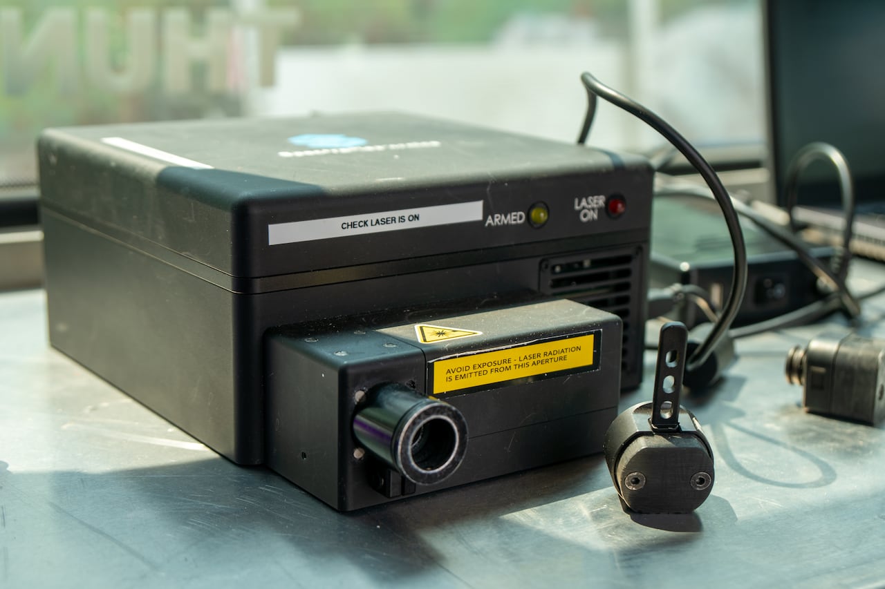 A close-up of a small black scanning machine on a table.