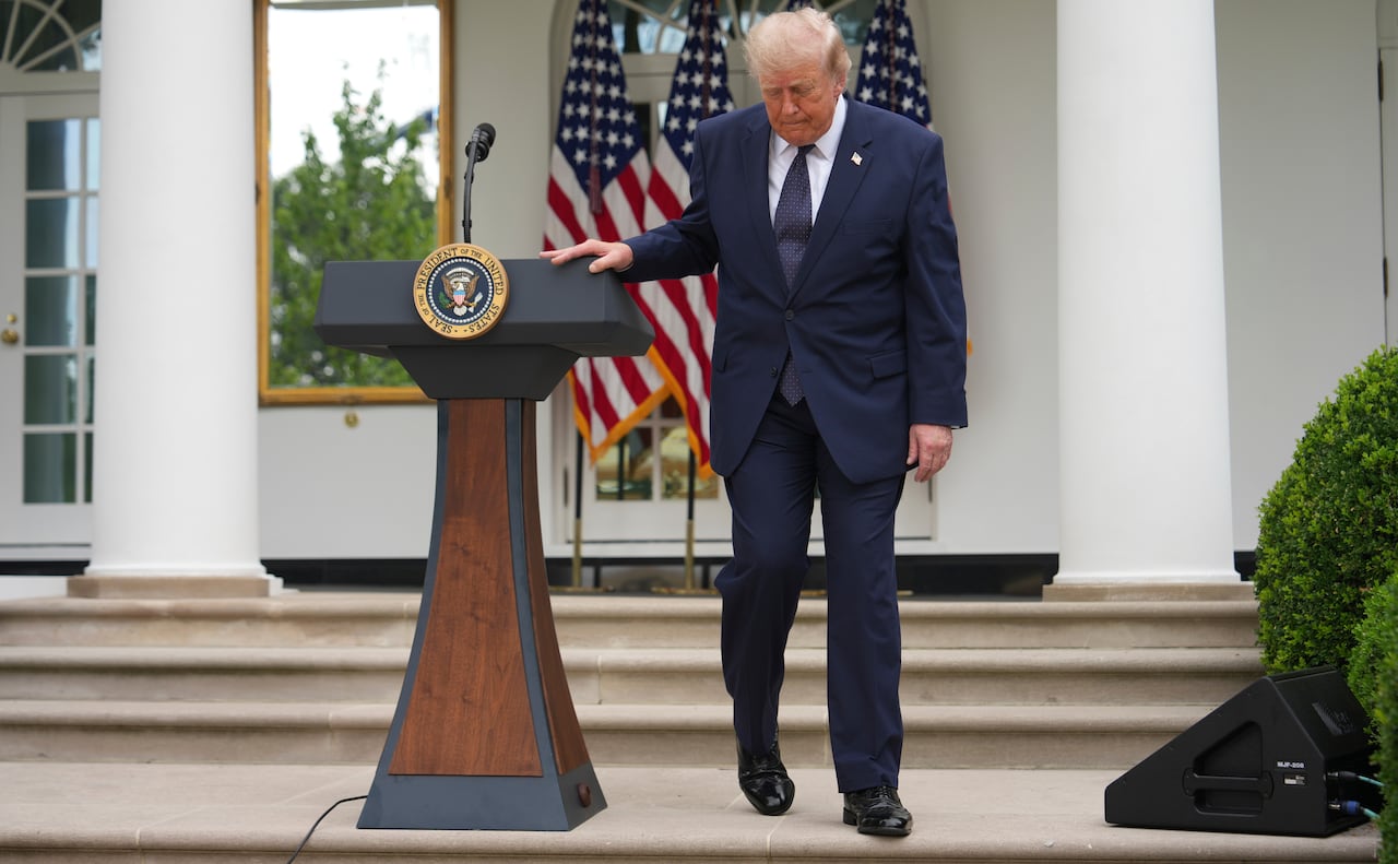 U.S. President Donald Trump steps away from a podium outdoors at the White House.