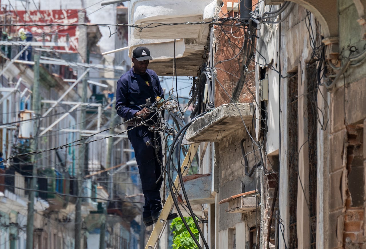 An electrician is seen working on the power grid in Havana, Cuba, amid a nation-wide power outage.
