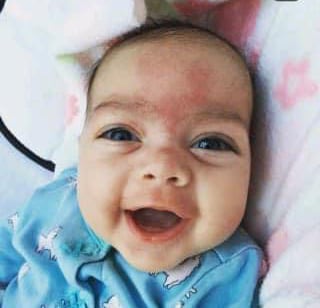 A baby, smiling.