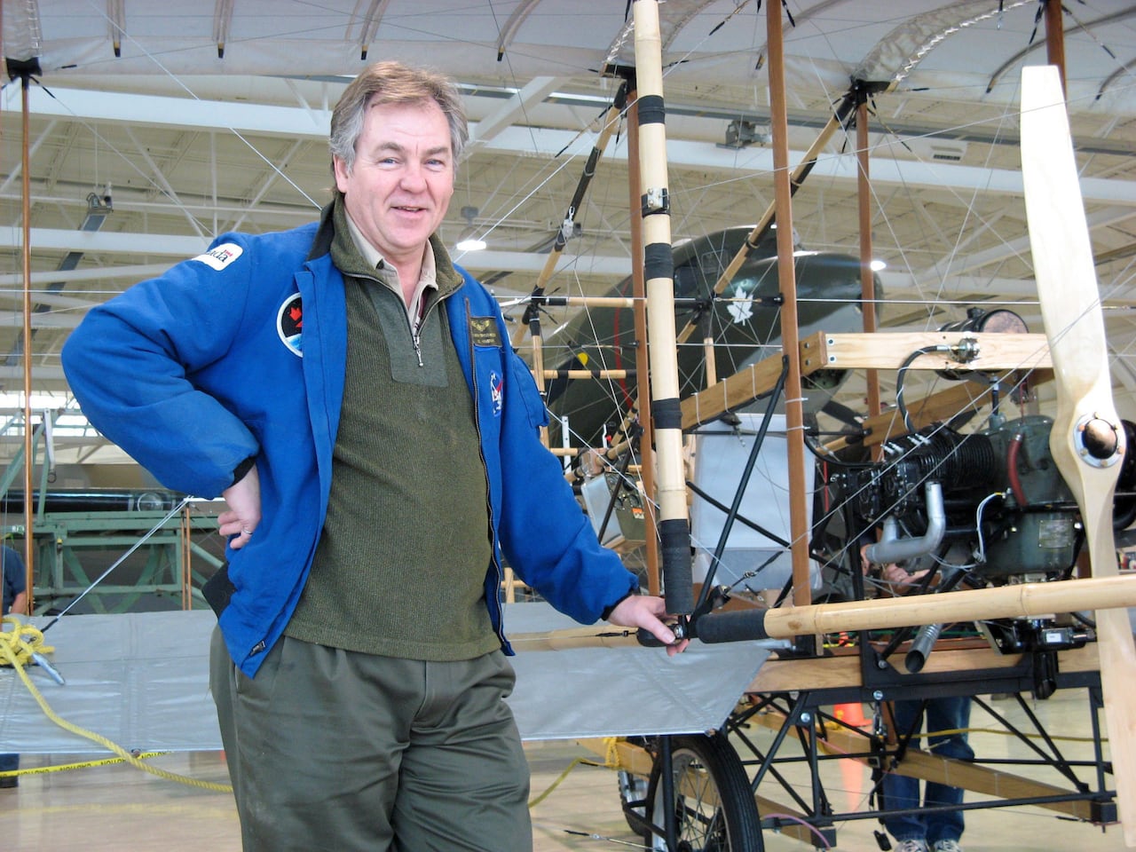 Bjarni Tryggvason posing alongside a replica of the famed Silver Dart biplane, in February 2009.