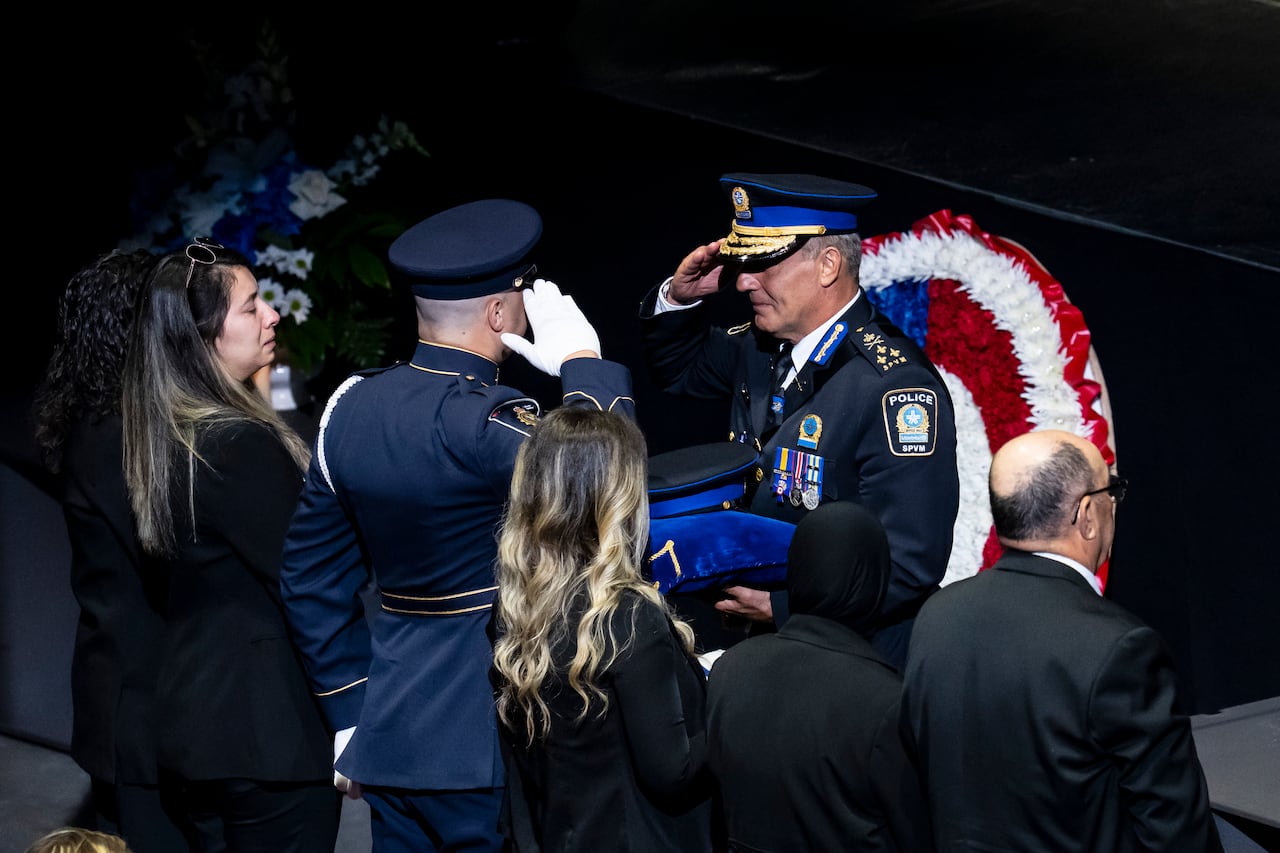 Montreal police Chief Fady Dagher gives a medal and the cap of fallen Montreal police officer Mohamed Lamine Benredouane to his family.