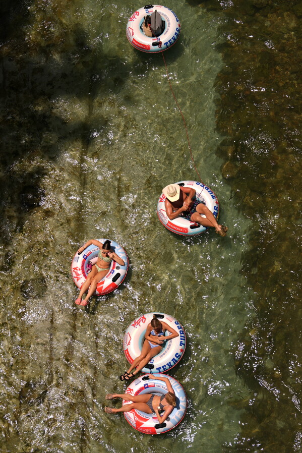 Tubers float along the cool waters of the Comal River in New Braunfels, Texas, Wednesday, July 1, 2026. (AP Photo/Eric Gay)