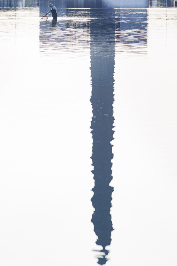 A worker clears debris from the Lincoln Memorial Reflecting Pool, Wednesday, July 1, 2026, in Washington. (AP Photo/Tom Brenner)