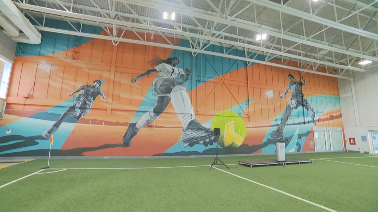 a mural featuring kids playing soccer inside the brampton soccer centre